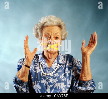 elderly woman with mouth taped closed Stock Photo