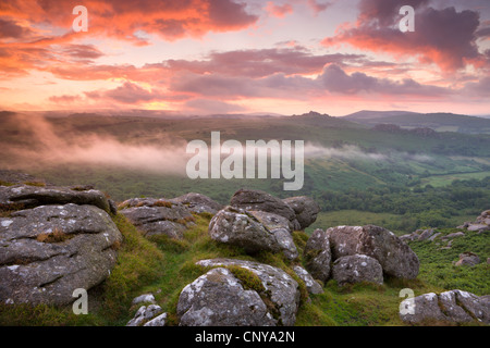 Dramatic sunset above a misty moorland near Hound Tor, Dartmoor National Park, Devon, England. Summer (July) 2010. Stock Photo