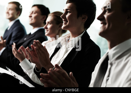 Tilt up of row of business people applauding to a successful speaker Stock Photo