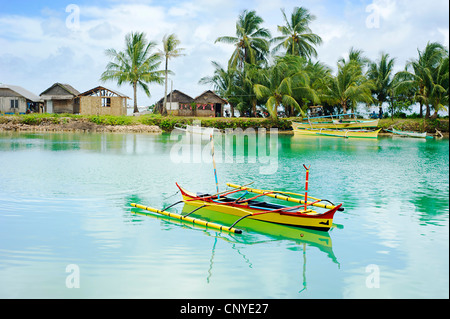 Tropical landscape with traditional Philippines boats and village on Calicoan island, Philippines Stock Photo