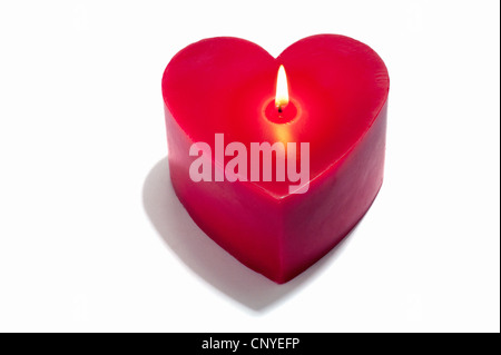A red heart shaped candle, lit Stock Photo
