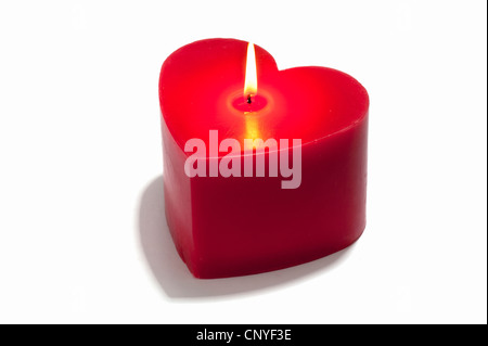 A red heart shaped candle, lit Stock Photo
