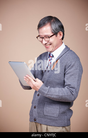 An old man looking at tablet PC Stock Photo