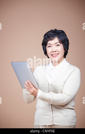 A smiling old woman with tablet PC Stock Photo