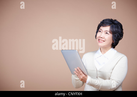 A smiling old woman with tablet PC Stock Photo