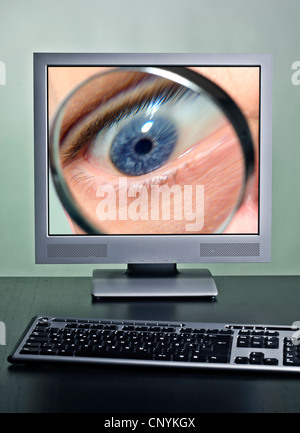 Eye with a magnifying glass on a computer screen as a symbol for monitoring over the Internet. Stock Photo
