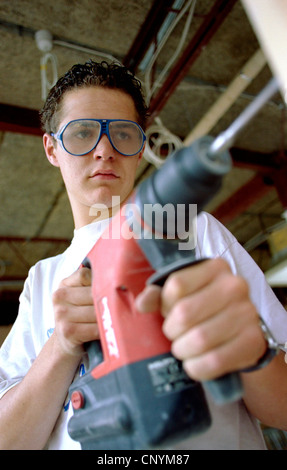 Young builder using a power drill. Stock Photo