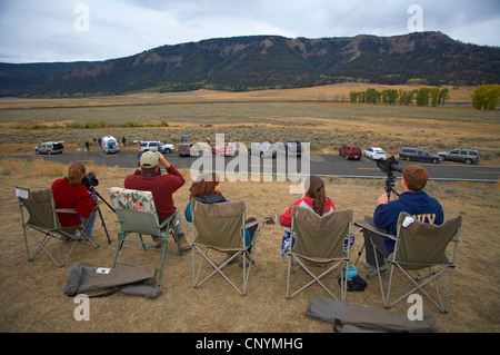 wolf watchers sitting in folding chairs looking out over a valley, USA, Yellowstone National Park, USA, Wyoming Stock Photo