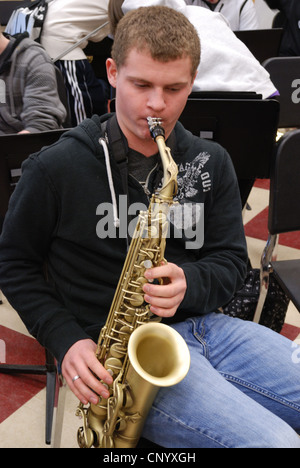 Teenage boy plays his sax in High School music class. Stock Photo