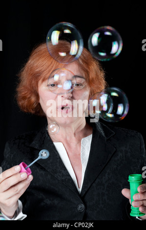 Middle aged woman blowing bubbles Stock Photo