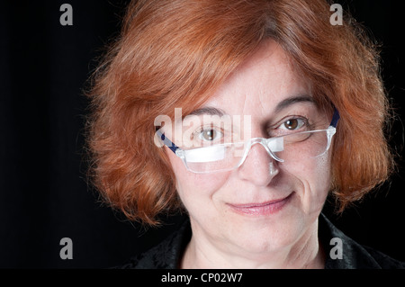 Middle aged woman with reading glasses smiling Stock Photo