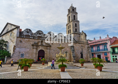Wide view of an urban scene in Old Havana with a view of typical houses and Church Stock Photo