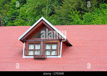 Old window on red shingled roof Stock Photo