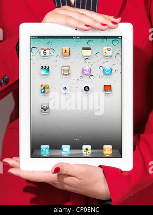 Closeup of a woman in red business suit holding a white iPad in her hands Stock Photo