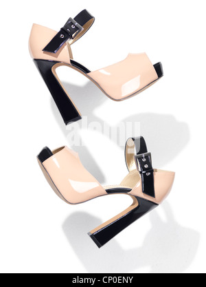 Pair of fashionable high heel platform womens shoes falling through the air isolated on white background Stock Photo