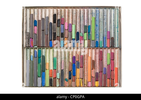 Top down view of large box of used, messy colored artist pastel chalks lying in vertical rows. Stock Photo