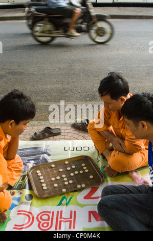 Vertical close up of Vietnamese men playing cờ tướng, a popular chess-like game in Asia, on the side of the road. Stock Photo