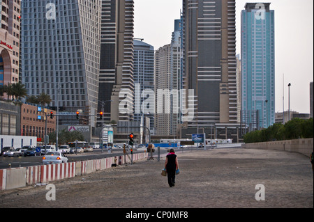 Skyscrapers with a lone figure of a woman Dubai Marina, Dubai, United Arab Emirates Stock Photo
