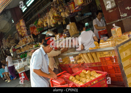 Horizontal close up of a street hawker setting up for business with baguettes being delivered in Vietnam. Stock Photo