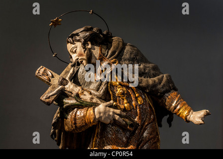 Carved figure of a saint holding a crucifix. Prague, Czech Republic Stock Photo