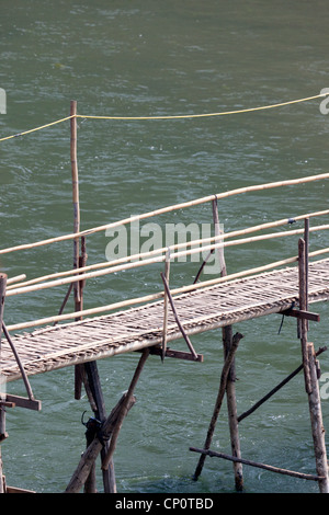 A flimsy bamboo footbridge thrown across the Khan river, a tributary of the Mekong (Luang Prabang - Laos) Passerelle en bambous Stock Photo