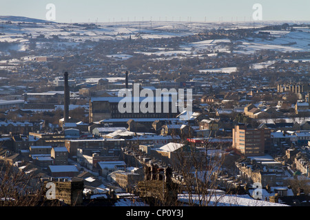 Looking down on Bradford City centre from Undercliffe Cemetary in winter. Ovenden Moor wind farm is on the horizon. Stock Photo