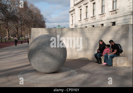 A family sit on the Memorial to the victims of the Bali bombing (Kuta Beach,12th October 2002), Horse Guards Road, London, UK Stock Photo