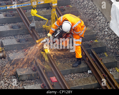 Railway worker cutting new track to correct length Stock Photo