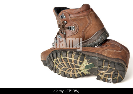 Dirty pair of hiking boots with grass and mud in the treads isolated on white Stock Photo