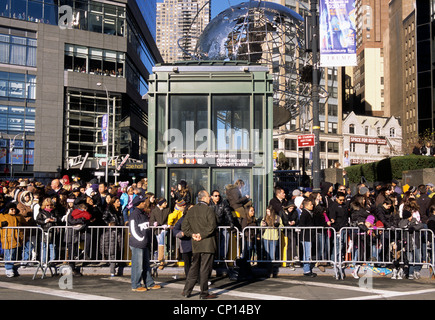 Macy's Thanksgiving Day Parade New York City. Crowd standing on the street behind barriers watching. Columbus Circle Midtown Manhattan. Stock Photo