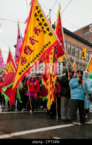 Participants of the 2012 Chinese New Year parade carry flags down the streets of Vancouver's China Town. Stock Photo