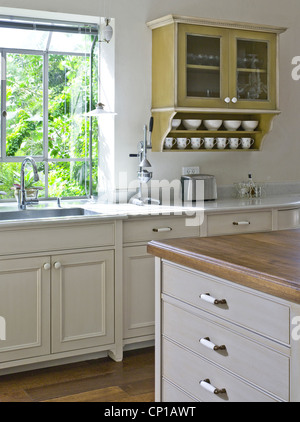 Wall mounted kitchen cabinet next to sink at window. Ramhash Munjak, Israel. Stock Photo