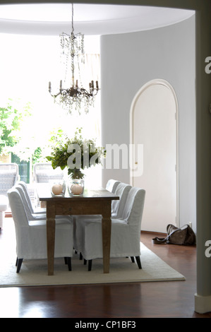 Dining room with slip covered chairs and chandelier, Marie Louise, ML Fabrics, Rijswijk, Holland. Stock Photo