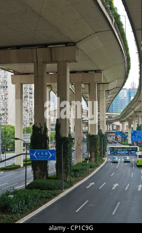 View under multi-lane raised highway in the centre of Shanghai, China, with bus crossing intersection. Stock Photo