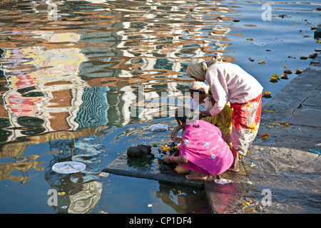 Indian women making a ritual offering (puja). Godavari river. Nasik. India Stock Photo