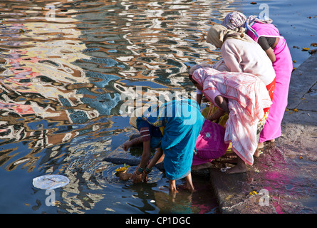 Indian women making a river offering. Nasik. Maharashtra. India Stock Photo