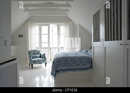 Double bed with blue pattern cover in modern country style bedroom Stock Photo