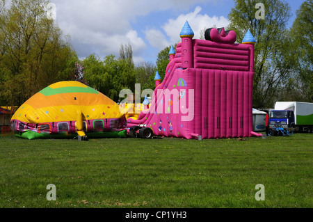 'Jump and Smile' inflatable house bouncy castle type attraction being inflated before fair opening in Debdale Park, Gorton Stock Photo