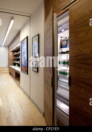 Modern apartment with light wooden flooring and walnut-faced hidden refrigerator, open Stock Photo