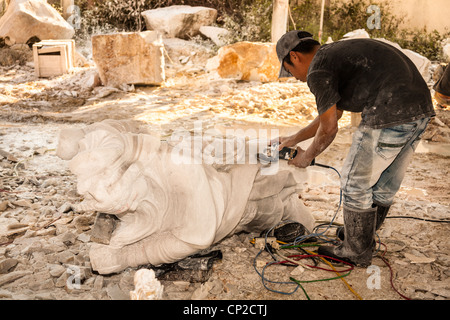 Man using an angle grinder in the manufacture of a stone statue, Tien Hieu factory, Danang, Vietnam Stock Photo