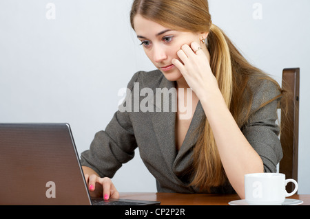 Concentrated young businesswoman working on laptop in the office Stock Photo