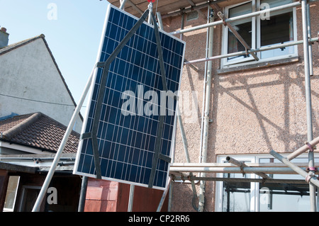 Solar panel being lifted to roof for installation on a UK home. Stock Photo