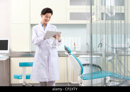 Dentist using digital tablet in dental clinic Stock Photo