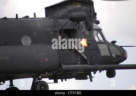 A US Army special operations door gunner fires a M134 minigun on a CH-47 Chinook during a training exercise January 4, 2004 at Fort Bragg, NC. Stock Photo