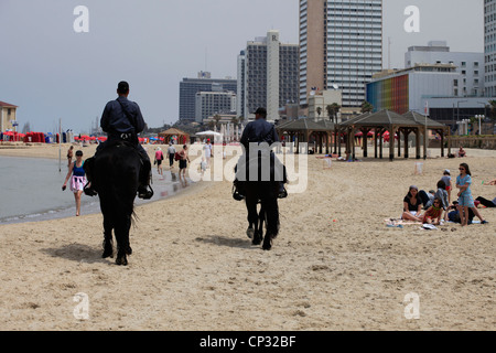 Israeli Policemen from the cavalry unit mounted on horses patrolling in Bugrashov or Bograshov beach at the Mediterranean seashore of Tel Aviv in Israel Stock Photo