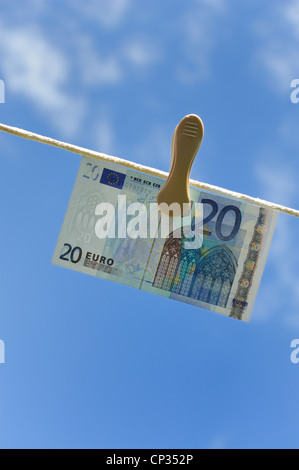 Euro note on a washing line with blue sky and clouds in the background england uk Stock Photo
