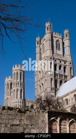 Ely Cathedral main West tower with smaller towers over Stained Glass Museum from south spring sunshine with blue sky Stock Photo