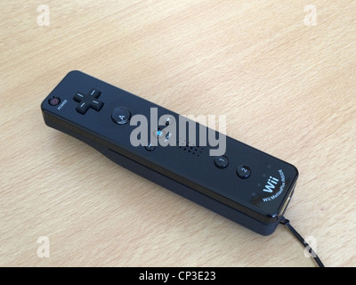 Close Up of a Nintendo Wii Black Remote Controller on a Wooden Surface Stock Photo