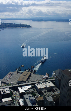 Two ferries arrive and depart from Seattle's downtown area en route to Bainbridge Island, Washington State. Stock Photo
