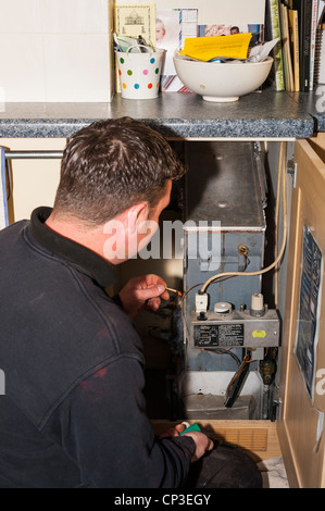 A plumbing and heating engineer servicing a gas boiler in the Uk Stock Photo